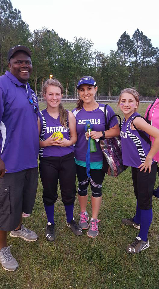 Brent and his wife with their two oldest coaching their softball team.