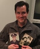 William holding pictures of his grandparents, also military veterans